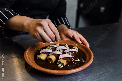 Fototapeta Naklejka Na Ścianę i Meble -  Latin woman chef cooking traditional mexican food in a restaurant kitchen in Mexico