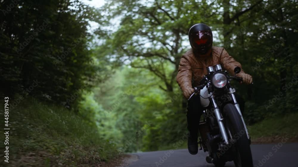 Person Driving With a Motorcycle on a Narrow Road in the Forest Person Driving With a Motorcycle on a Narrow Road in the Forest