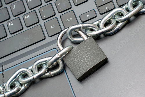 Fotografie an iron chain fastened with a padlock on a computer keyboard the concept of data