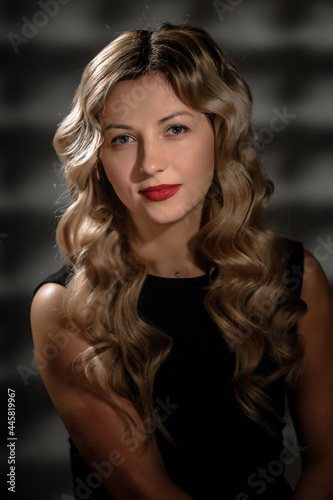 Fashion studio portrait of beautiful girl with blonde curly hair