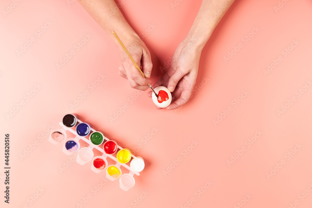 A girl paints eggs red for Easter A girl paints eggs red for Easter