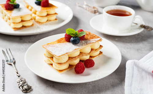 Classic french dessert millefeuille with vanilla cream and fresh berries.