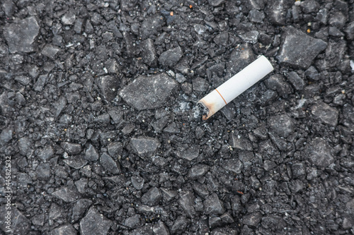 closeup of smashed cigarette butt on asphalt with copy space