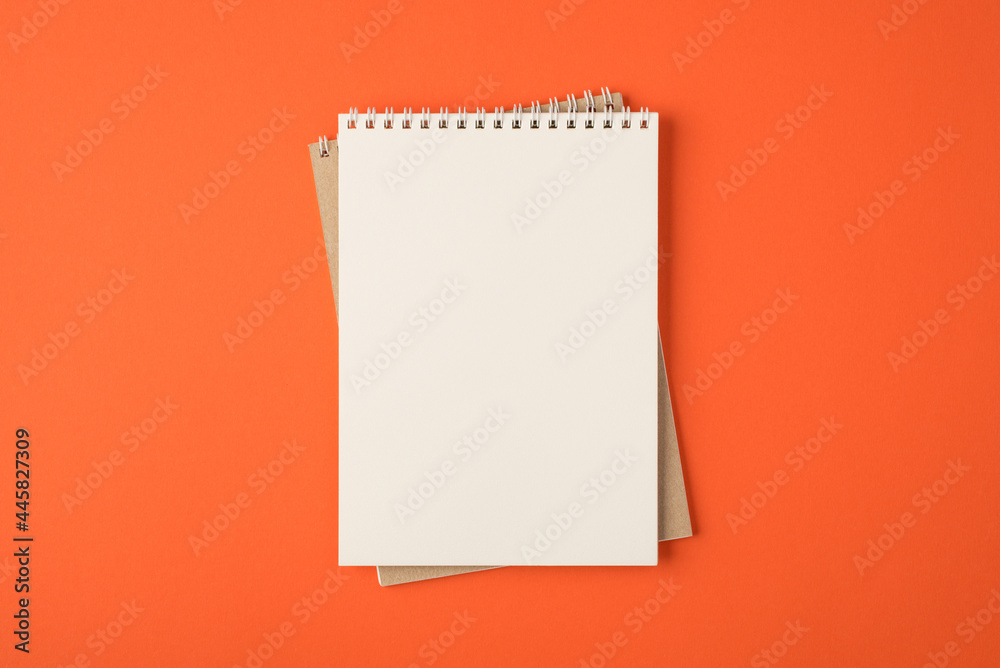 Top view photo of spiral notebooks on isolated vivid orange background with blank space Top view photo of spiral notebooks on isolated vivid orange background with blank space