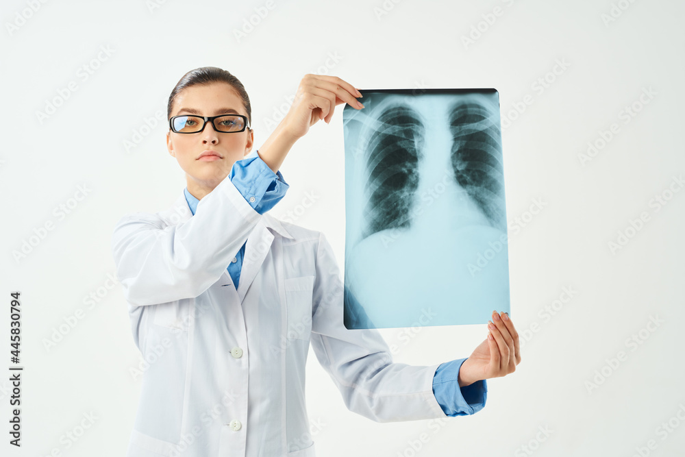 female doctor holding an x-ray in front of her hospital treatment diagnosis