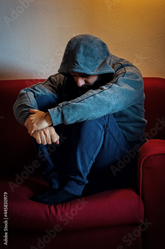 Depressed man sitting alone on a couch
