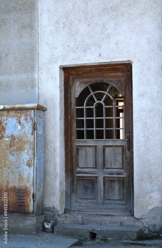 an old wooden door on an abandoned house in the city