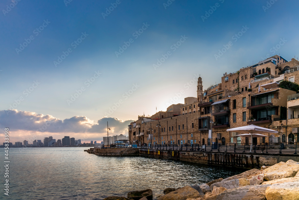 View of street facing the old port of Jaffa in Israel with a colorful sunrise on Tel Aviv