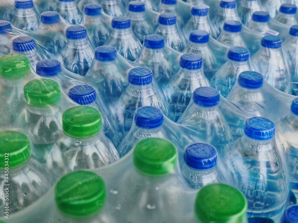 High Angle View of Packs of Bottled Drinking Water with Blue and Green Caps High Angle View of Packs of Bottled Drinking Water with Blue and Green Caps