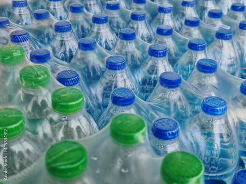 High Angle View of Packs of Bottled Drinking Water with Blue and Green Caps photo