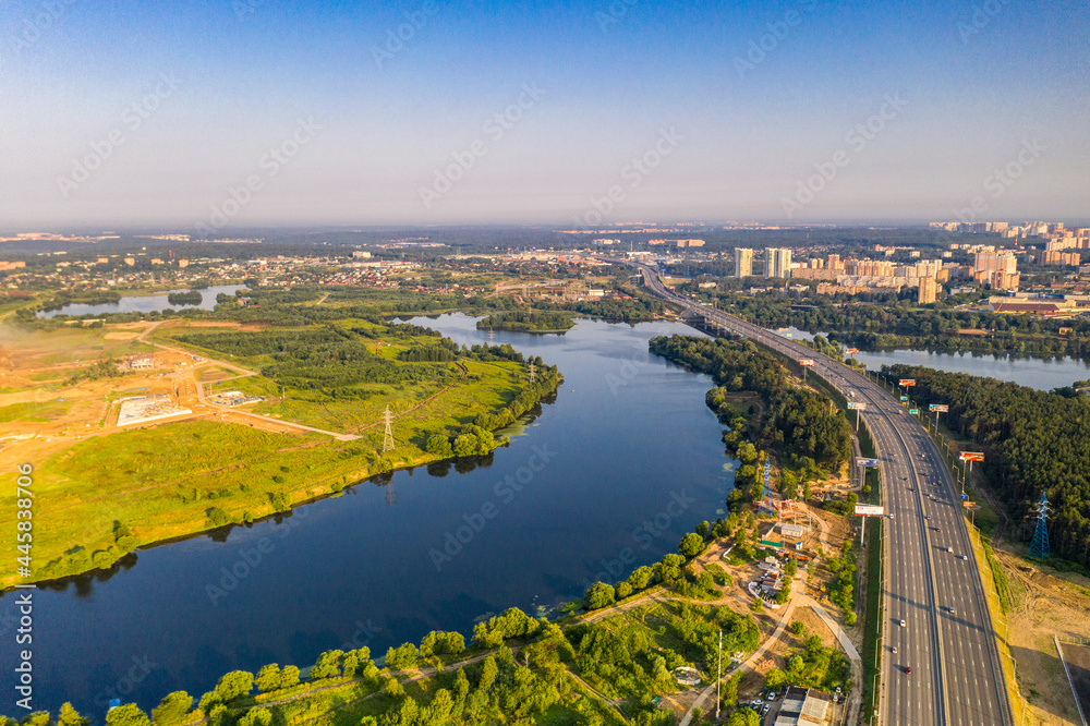 panoramic view of a green residential area near the lake filmed from a drone 