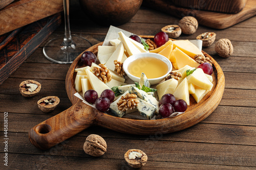 Cheese wine appetizer platter with grapes nuts and honey
