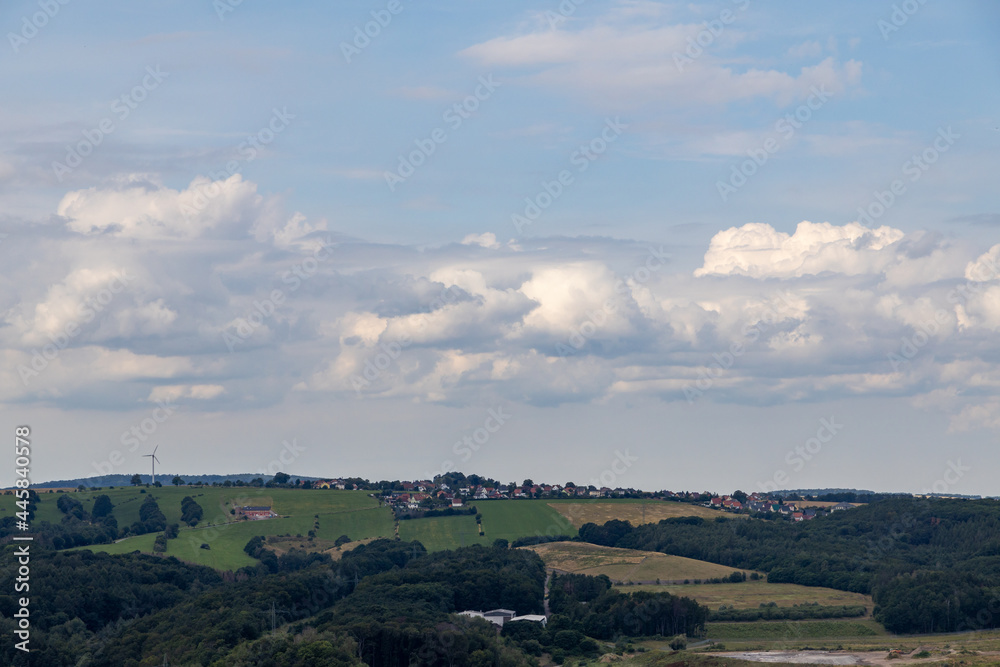 a beautiful landscape with fields, villages, a blue sky and white clouds. 