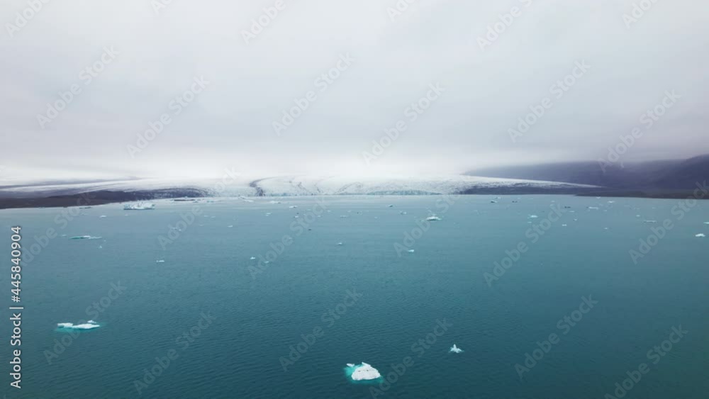 Icebergs Scattered in the Ocean With the View of the Mountains on Clear Sky Icebergs Scattered in the Ocean With the View of the Mountains on Clear Sky