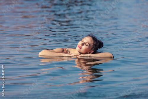 Young woman on the background of the sea, close-up. The concept of summer vacation, skin care and health, relaxation..