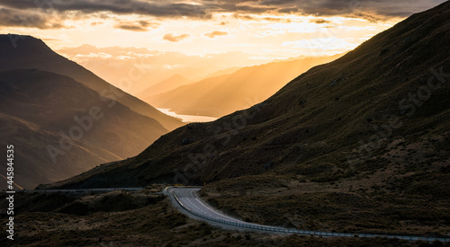 The beautiful road between Queenstown and Wanaka via Crown range. Grassland and beautiful landscape of rocky mountains.