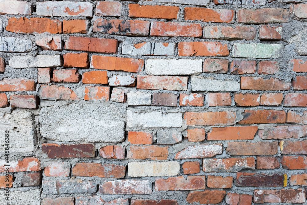 Fototapeta premium The old wall is made of different bricks and blocks. Abstract background image