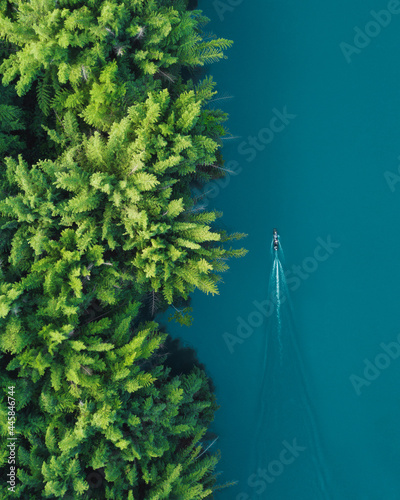 Aerial view of river side in tropical rain forest with local people on the boat. 