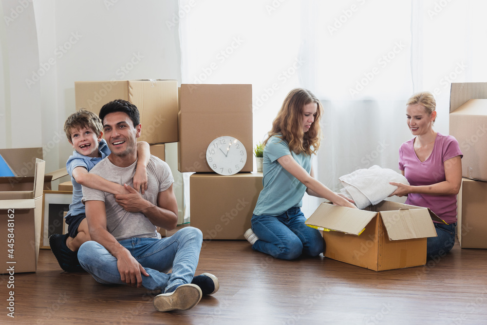 Parents and children sit floor Unpacking During move new home. Parents and children sit floor Unpacking During move new home.