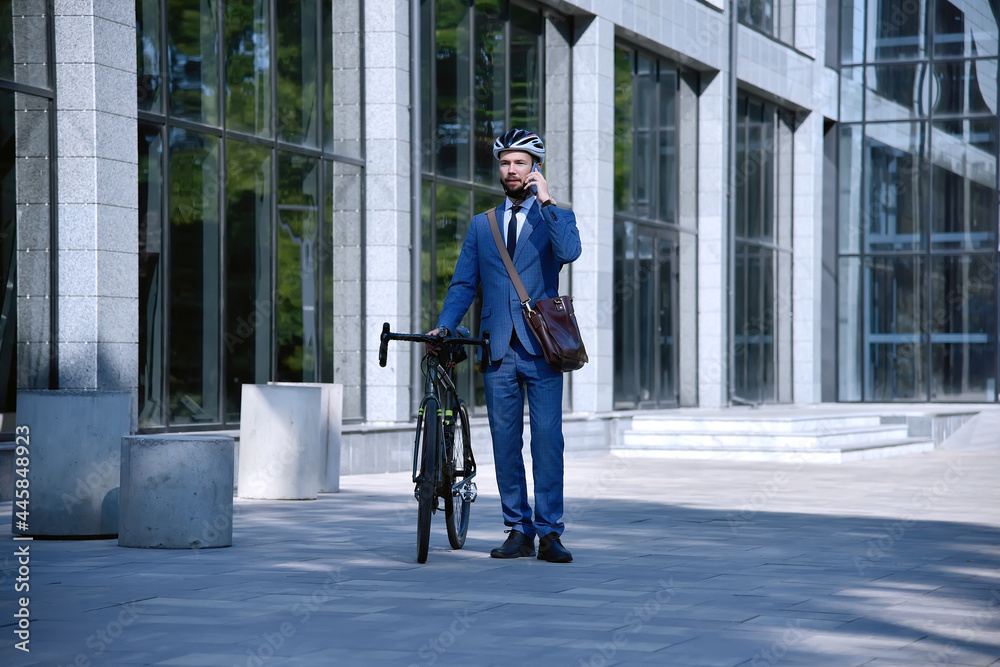 Businessman talking on mobile phone with bike.