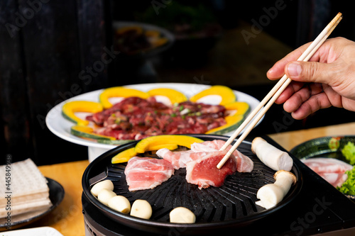 Korean grilled pork on the grill with meat in the plate 