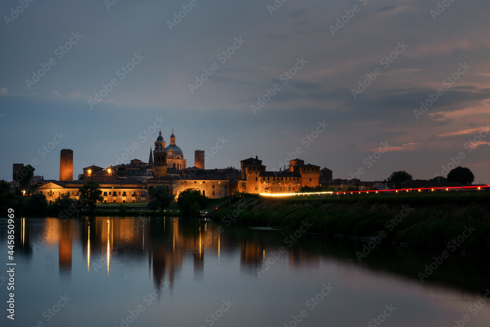 The Mantua (Mantova) skyline at dusk. Beautiful Italian city reflecting on the Mincio river waters.