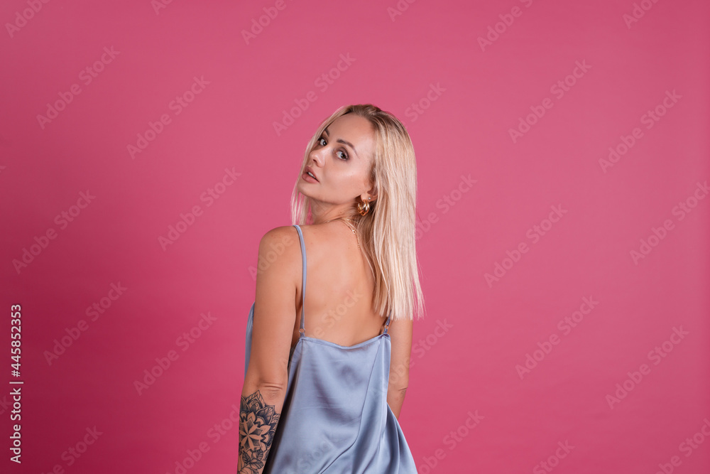 Beautiful blonde woman in elegant silk dress isolated on pink background with pretty makeup big lips posing Beautiful blonde woman in elegant silk dress isolated on pink background with pretty makeup big lips posing