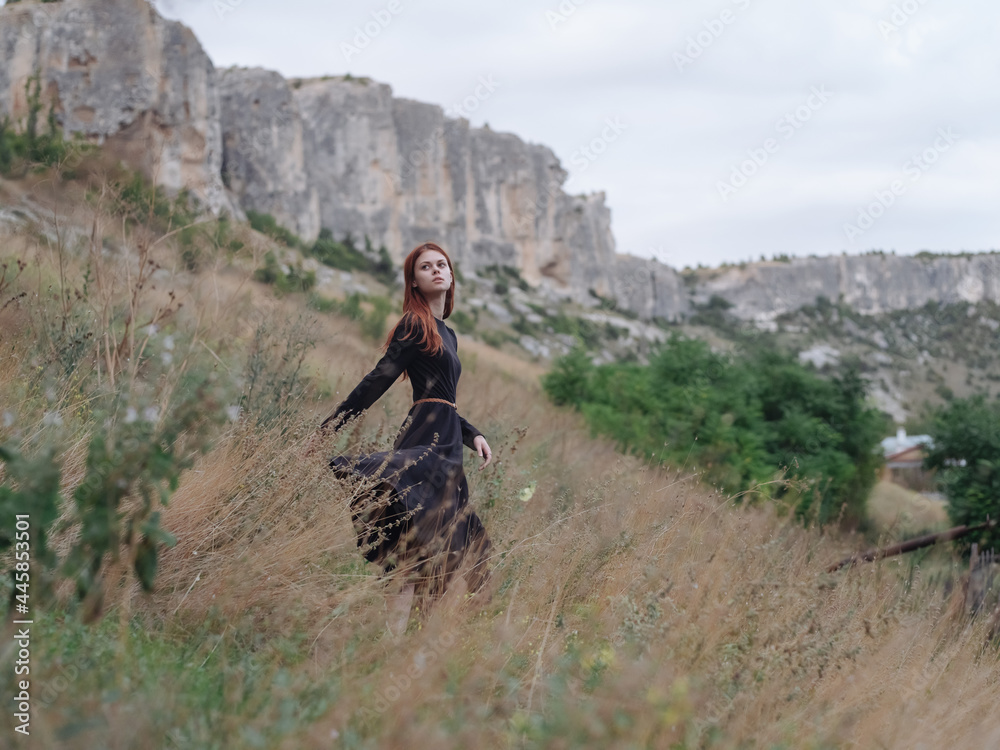 pretty redhead woman in black dress walk landscape freedom