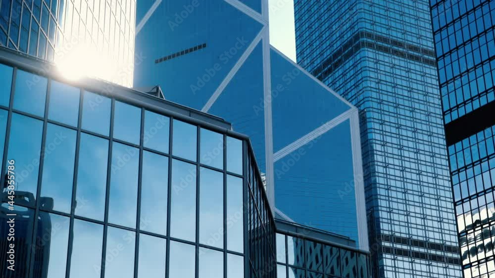 Abstract modern business architecture with sunlight reflections. Walls made of glass and steel with reflections of buildings and blue sky. Abstract modern business architecture with sunlight reflections. Walls made of glass and steel with reflections of buildings and blue sky.
