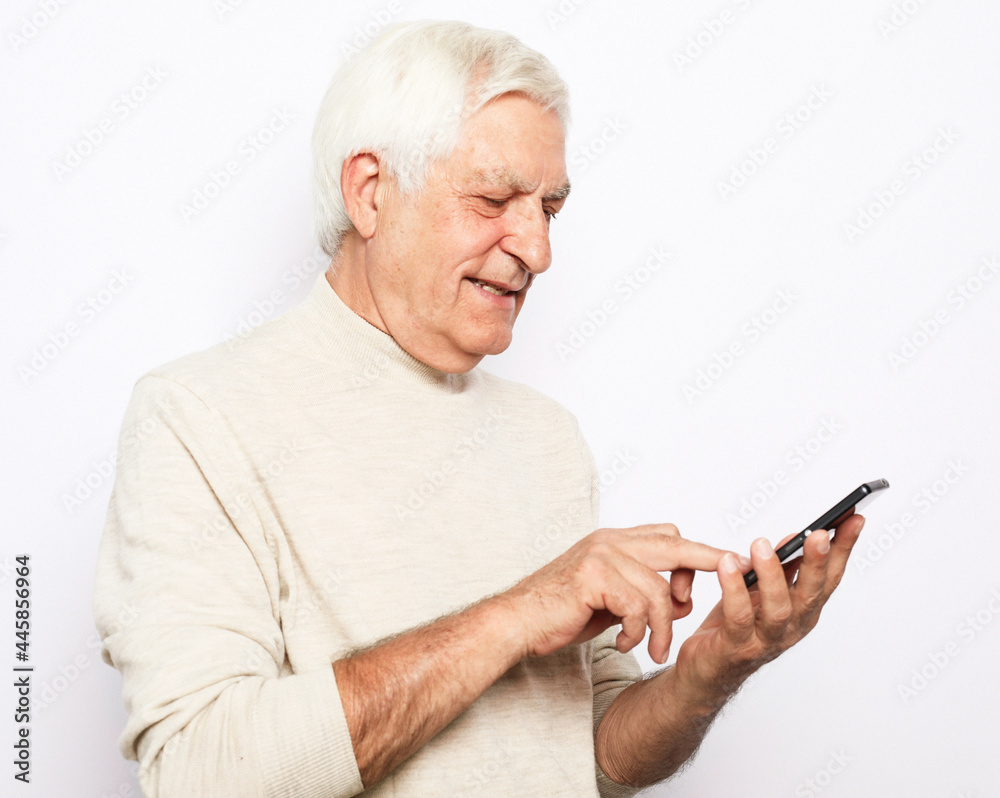 senior man in casual outfit cheerfully smiling and using modern smartphone senior man in casual outfit cheerfully smiling and using modern smartphone