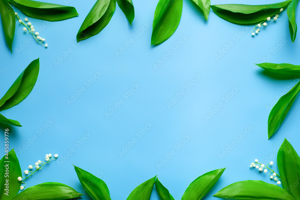 small bouquets of spring flowers as a floral frame with copy space. Flat lay with blue background. small bouquets of spring flowers as a floral frame with copy space. Flat lay with blue background.