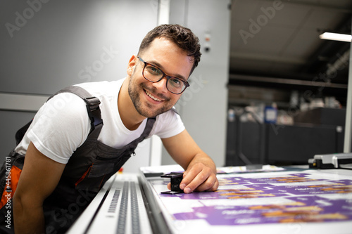 Portrait of an experienced print worker controlling print quality in modern printing house.