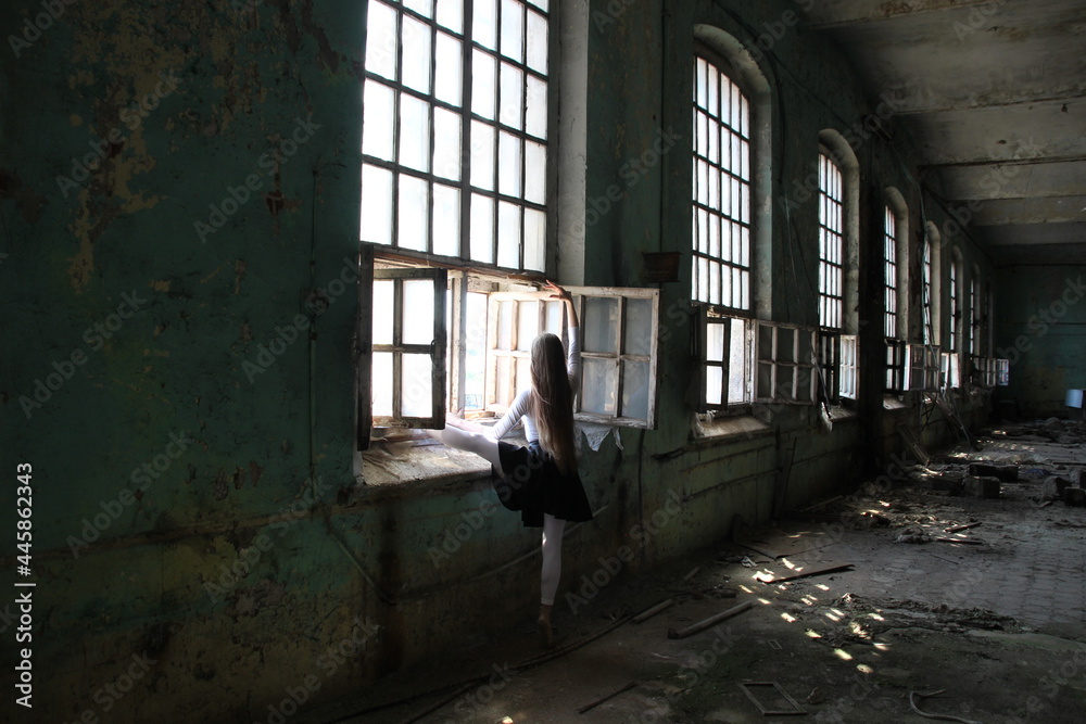 Long hair ballet dancer woman dance near window in old abandoned factory