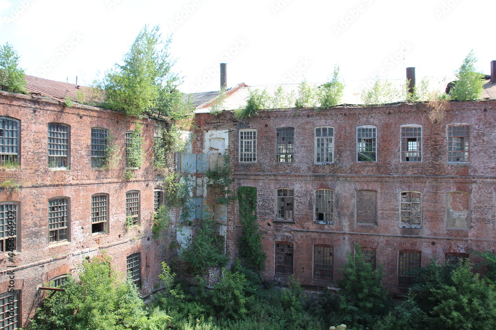 Backyard of old red brick abandoned textile factory in Ivanovo in sunny summer day