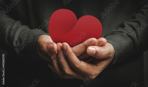Love, Health Care, Donation and Charity Concept. Close up of Volunteer Holding a Heart Shape Paper photo