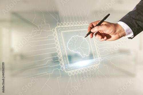 Man hand with pen working with virtual creative artificial Intelligence hologram with human brain sketch on blurred office background. Multiexposure