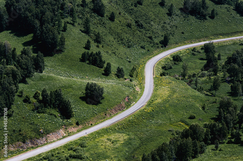 asphalt serpentine road among green hills