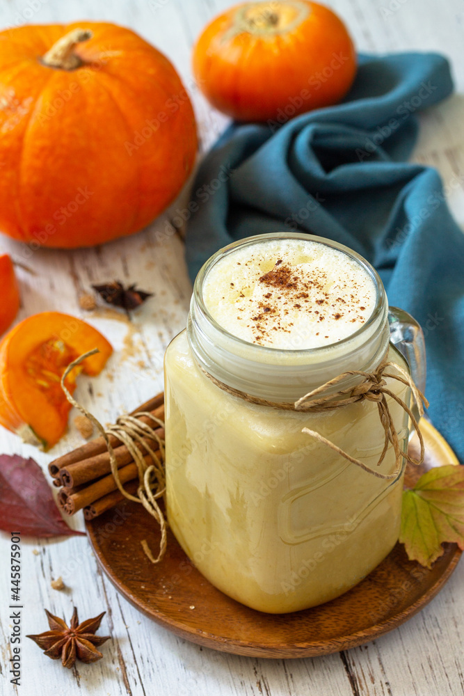 Autumn drink. Pumpkin spiced latte or coffee in glass on a rustic wooden table. Autumn drink. Pumpkin spiced latte or coffee in glass on a rustic wooden table.