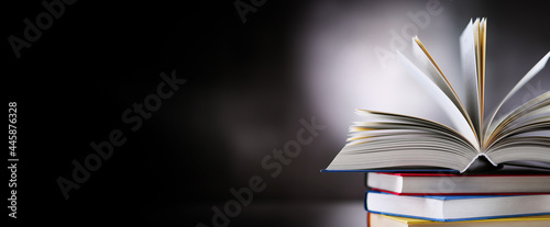 Hardcover book lying on a stack of other books