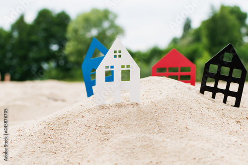 Models of houses stand in the sand