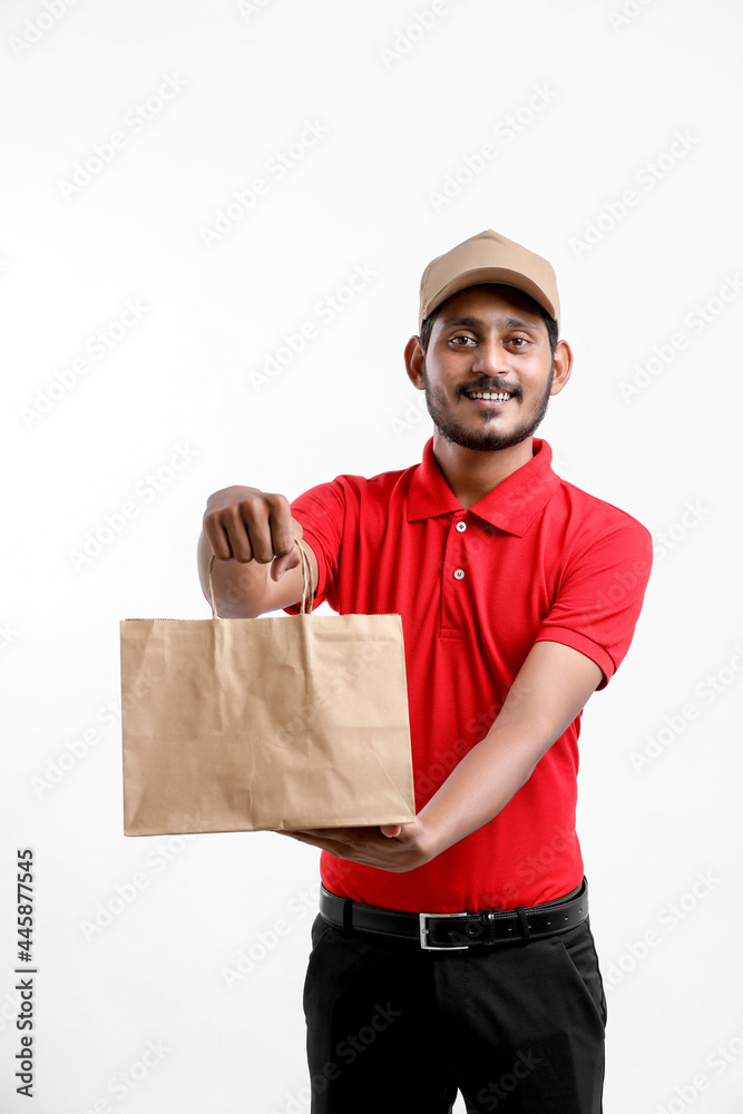 Happy Asian man in t-shirt and cap holding empty box isolated over white background, Delivery service concept