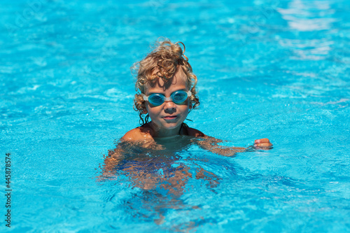 Curly boy in the pool with glasses © Maygutyak