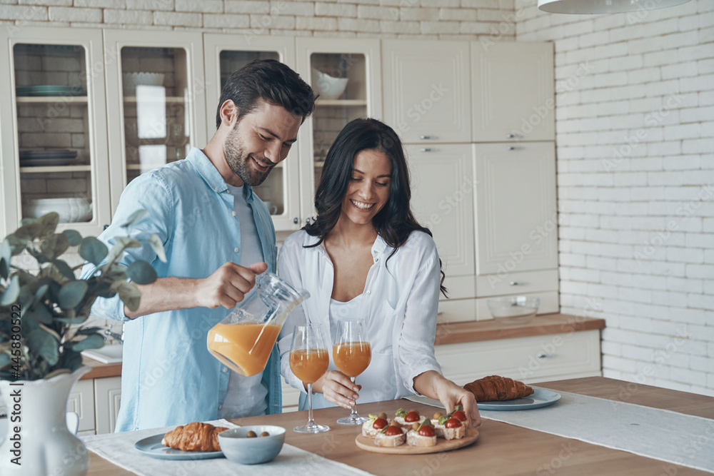 Beautiful young couple preparing breakfast together while spending time in the domestic kitchen