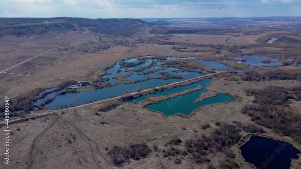 Small lakes separated by islands. Rural dirt road. Small hills. The sun's rays are reflected off the water. Natural tranquility Small lakes separated by islands. Rural dirt road. Small hills. The sun's rays are reflected off the water. Natural tranquility