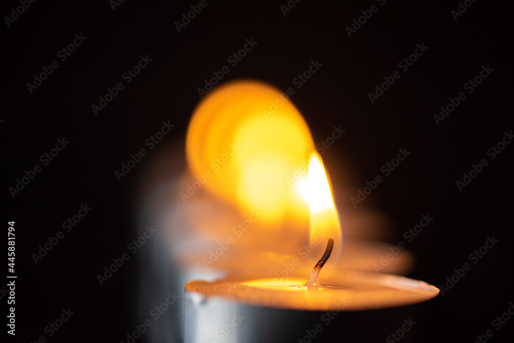 The bright flame of a dying candle on a dark background close-up. The bright flame of a dying candle on a dark background close-up.