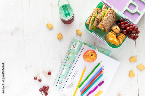 Top down view of school supplies and lunch on a light background. Back to school concept.
