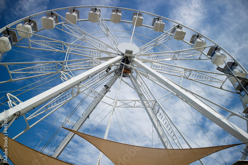 Ferris wheel of white color in blue sky