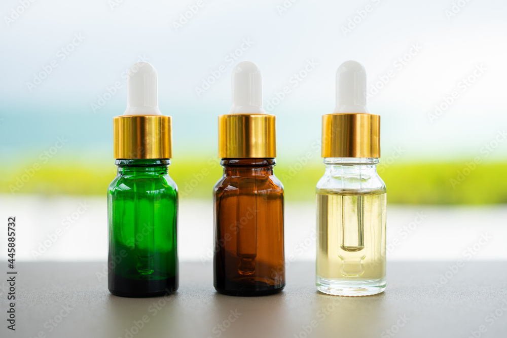 Set of multi color glass bottles with dropper on the table. Concept of aroma oil, cosmetic and beauty skin. Set of multi color glass bottles with dropper on the table. Concept of aroma oil, cosmetic and beauty skin.
