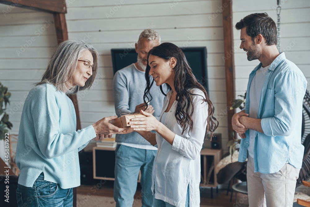 Fototapeta premium Happy senior parents meeting young couple inside the house
