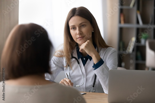 Serious doctor visiting senior female patient  giving consultation  recommendations  listening to complaints. Mature woman complaining on healthcare problems to physician in white coat